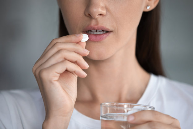 woman taking pill with water for the Medication-Assisted Treatment Near Clearwater fl